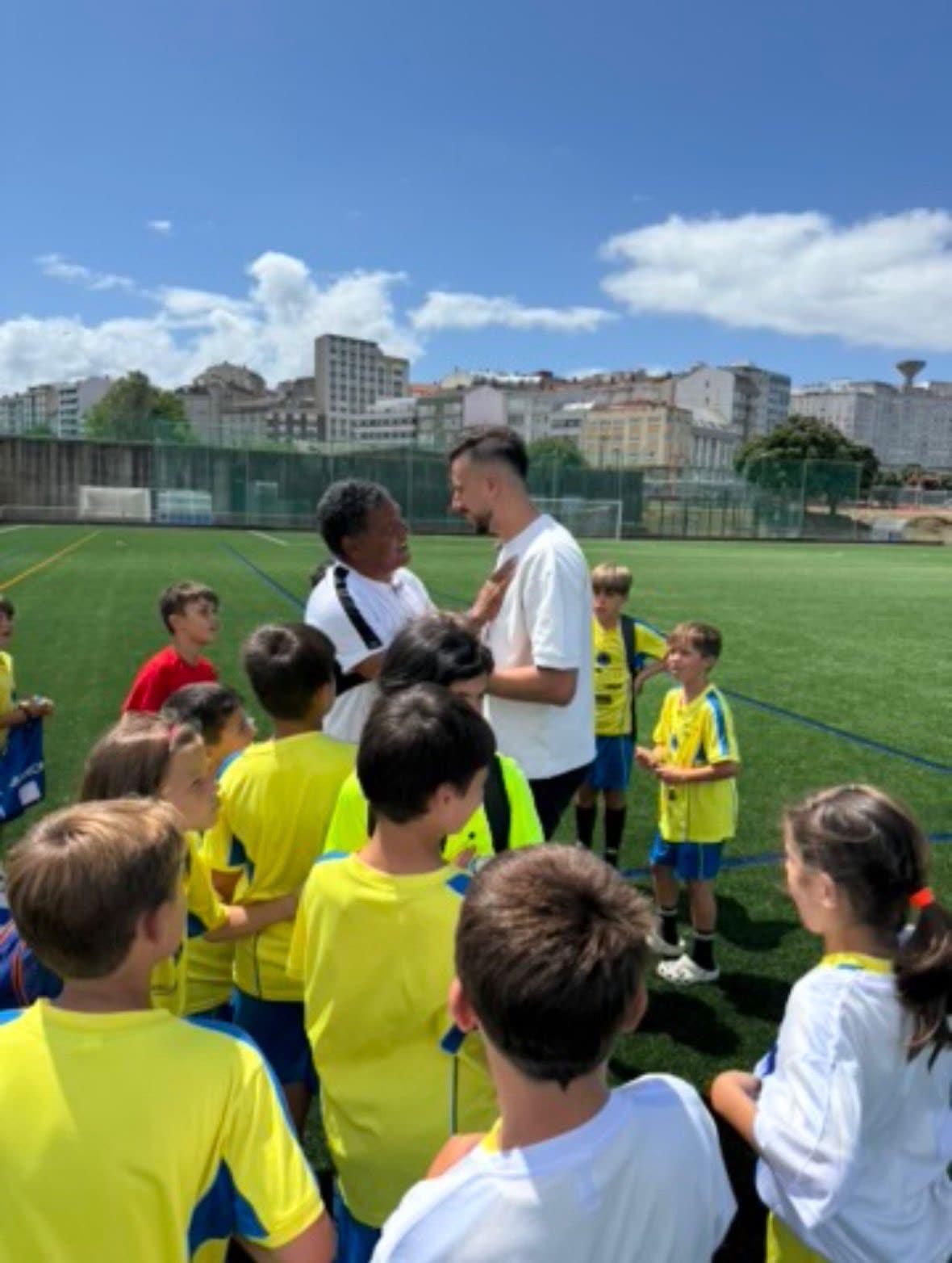 Donato Gama da Silva con un entrenador y niños del Campus