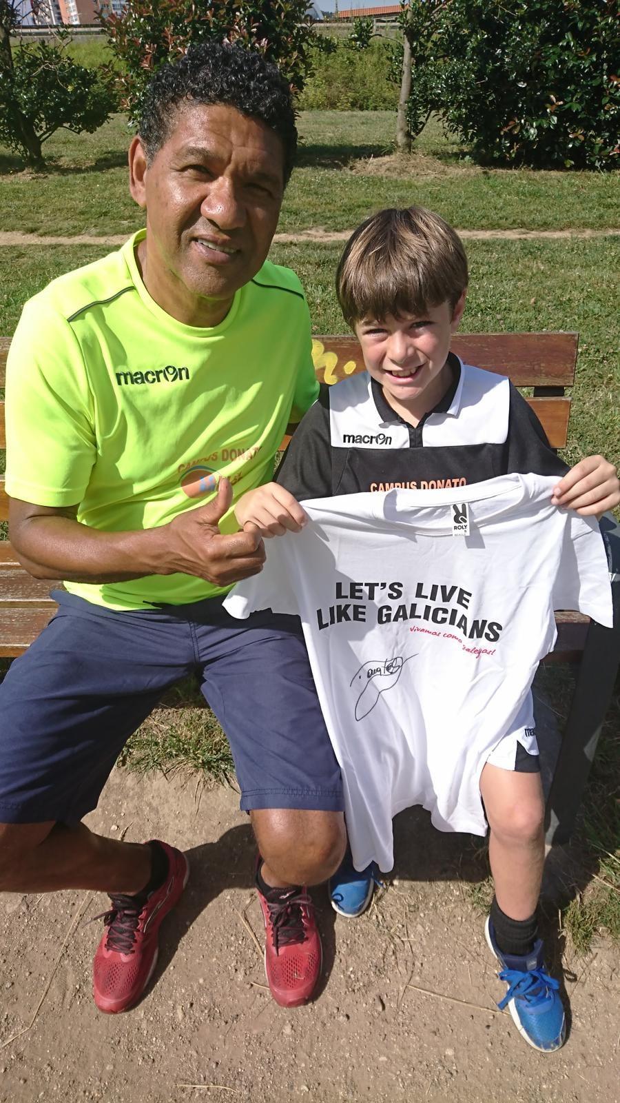 Donato Gama da Silva con un joven jugador del Campus Donato y la camiseta firmada